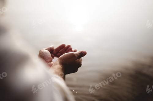Preview: High angle shot of Jesus Christ holding water with his palms