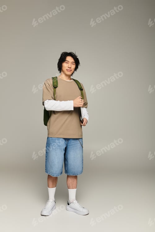 Preview: Stylish young asian man poses confidently in urban fashion attire with modern vibes