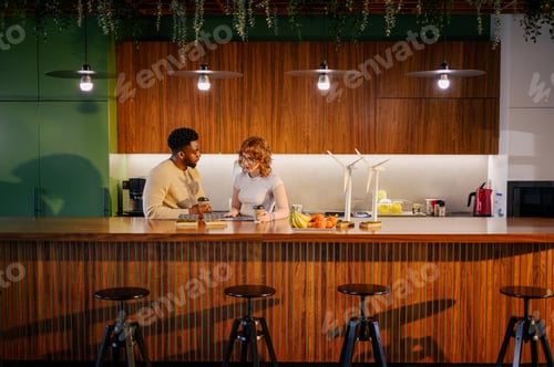 Preview: Interracial colleagues discussing wind power at eco friendly workspace