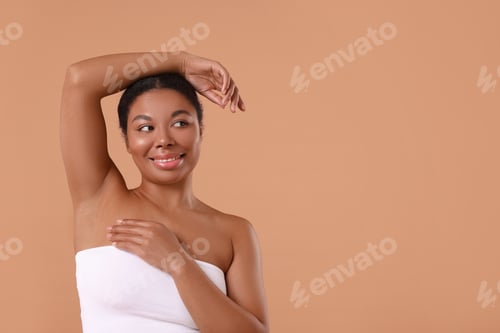 Preview: Woman showing hairless armpit after epilation procedure on beige background, space for text