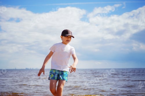 Preview: Happy little boy is running in the sea on sunny summer day. Childhood concept