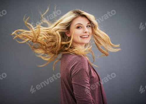 Preview: Portrait of a young woman standing against a gray background