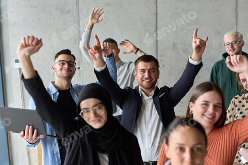 Preview: A diverse team of business professionals ecstatically celebrating their success in a modern office