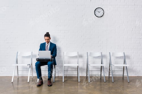 Preview: Businessman working on laptop while sitting on chair
