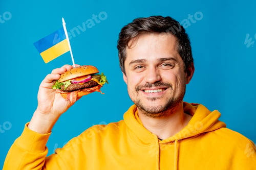 Preview: white guy in yellow hoodie with hamburger and Ukrainian flag on blue background