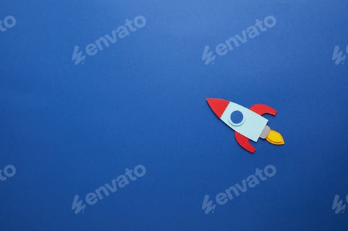 Preview: creative rocket on blue paper background