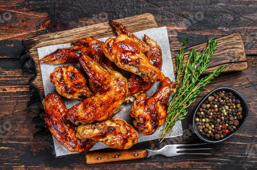 Preview: Baked Bbq chicken wings with dip sauce. Dark wooden background. Top view