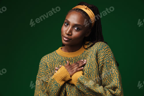 Preview: Young black woman holding hands on her chest and looking at camera