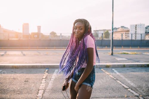 Preview: young black beautiful woman outdoor listening music holding smartphone