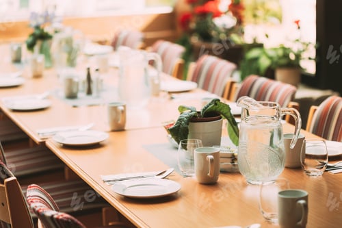 Preview: Cozy Interior Of Summer Cafe. Jug Of Icy Cold Ice Water On Table And Cutlery Laid Out