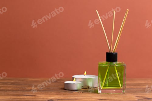 Preview: Relaxing home decor with green aroma diffuser and lit candles on wooden table