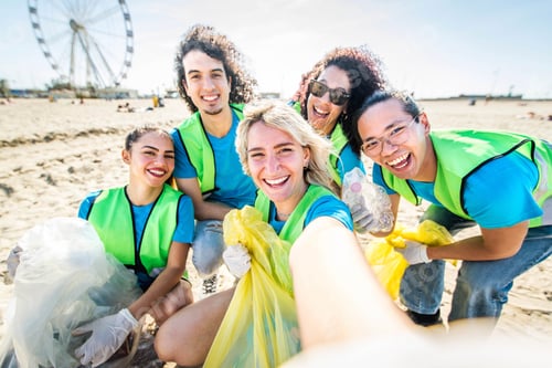 Preview: Group of eco volunteers picking up plastic trash on the beach
