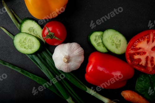 Preview: top view of vegetables as sliced cucumber, scallion, garlic, tomato and others on black background