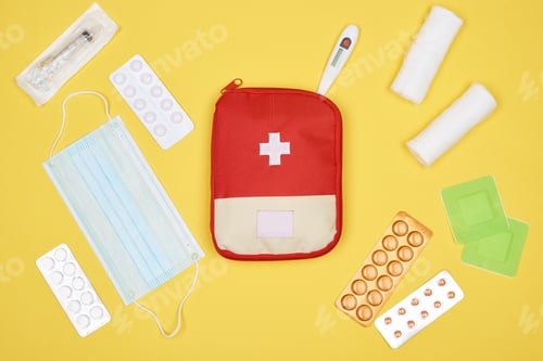 Preview: top view of first aid kit with various medicines isolated on yellow