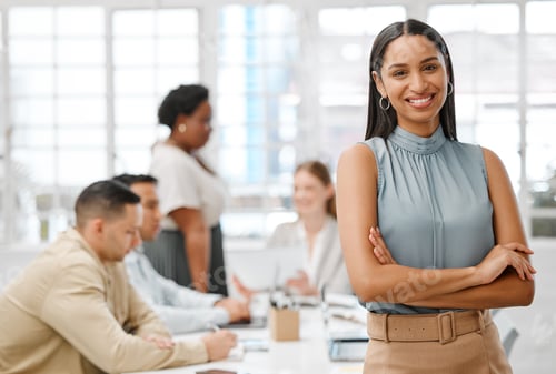 Preview: Smiling, happy and motivated young business woman with arms crossed showing great leadership to her