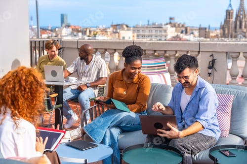 Preview: Diverse team collaborating during outdoor rooftop coworking meeting