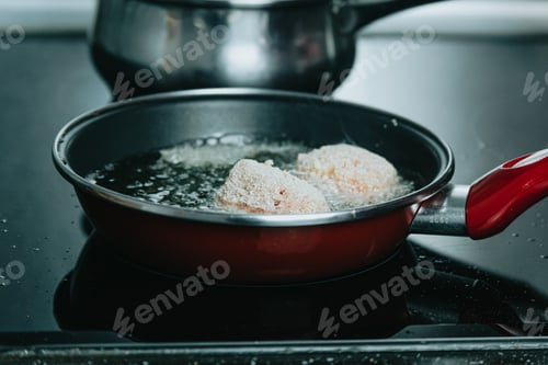 Preview: An old spanish woman frying meatballs on the kitchen