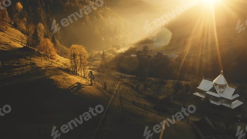 Preview: Sunset over fir mountain forest aerial. Autumn nature landscape. Rural cottages at sun mount valley