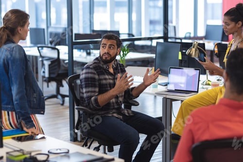 Preview: Diverse group of creative colleagues talking at casual meeting