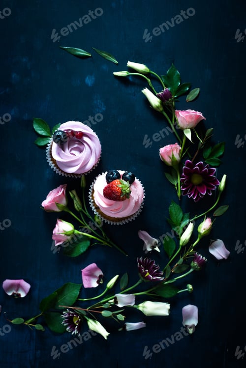 Preview: Cupcakes with strawberries and rose flowers on a dark background. Spring dessert concept with copy