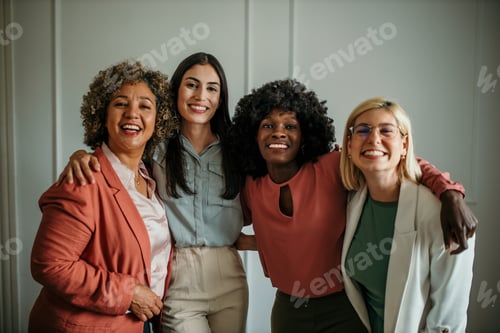 Preview: Four businesswomen smiling and embracing each other in office environment