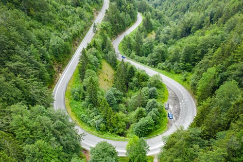 Preview: Aerial view of mountain road in the forest with moving cars