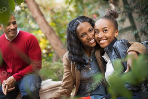 Preview: Two adults and a teenage girl, mother and daughter hugging.