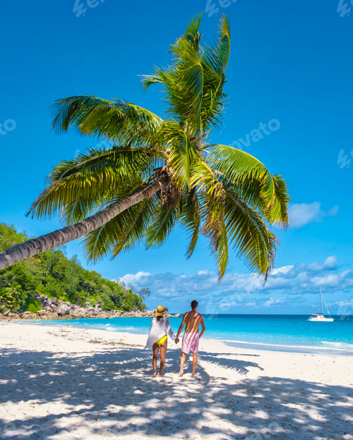 Preview: Anse Georgette Praslin Seychelles, young couple men and woman on a tropical beach during a luxury