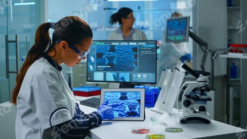 Preview: Lab technician doctor analyzing virus evolution looking on digital tablet