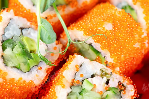 Preview: A piece of sushi or rolls with red caviar and sprouted herbs