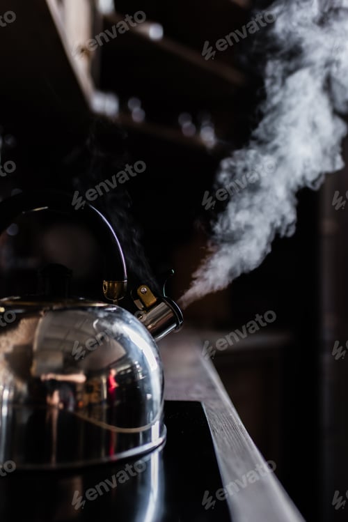Preview: Close-up view of metallic kettle boiling on electric stove