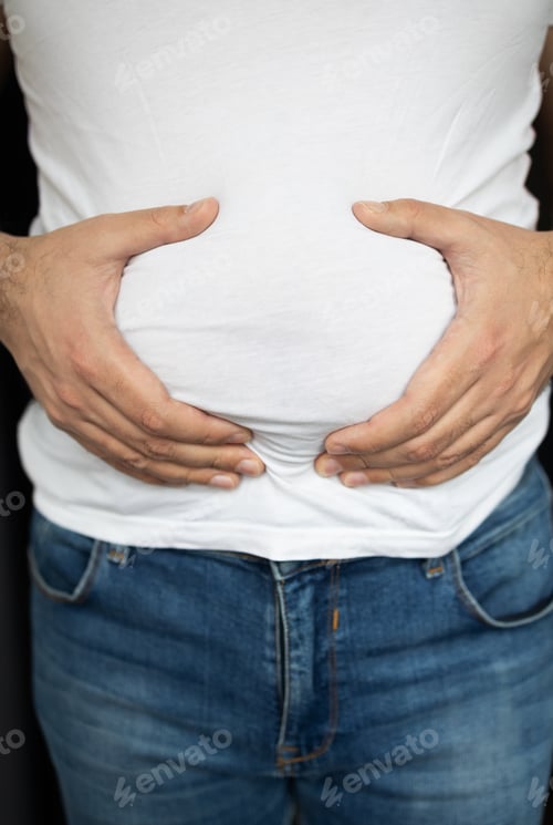 Preview: Man in t-shirt touching his stomach