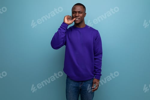 Preview: charming cute young african guy in a blue sweatshirt communicates an idea