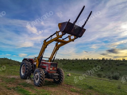 Preview: Beautiful view of a tractor in the field under a cloudy sky