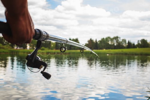 Preview: a man with a fishing rod on the river bank is fishing