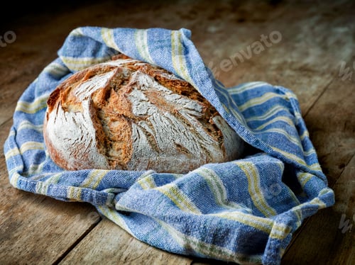 Rustic Bread Loaf Wrapped in Cloth on Wood