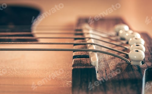 Preview: Acoustic guitar bridge and strings close up.