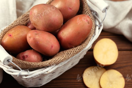 Preview: Freshly harvested red potatoes in a basket on a wooden table