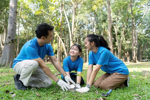 Preview: Family volunteers joyfully planting a tree together for a healthier environment