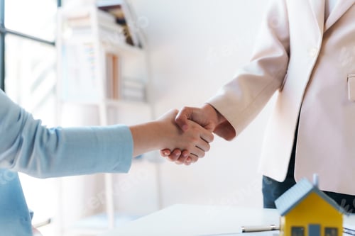 Preview: Real estate agent shakes hands with a client to sign a home purchase contract congratulating