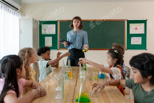 Preview: Adorable student learn with teacher in classroom at elementary school.