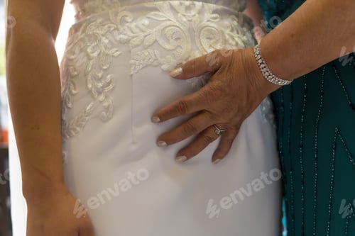 Preview: Mother of the bride giving hands to the bride in the morning before the ceremony