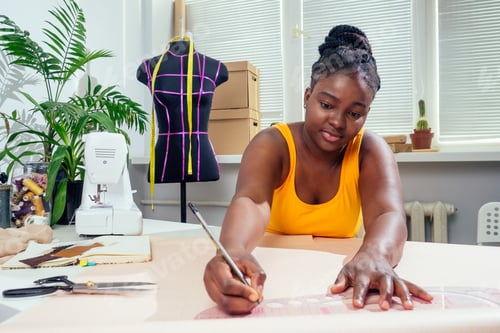 Preview: afro woman drawing pattern plotting paper in workshop