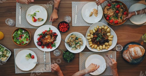 Preview: Family home, top view and thanksgiving food on table with hands, plate and dish for festive celebra