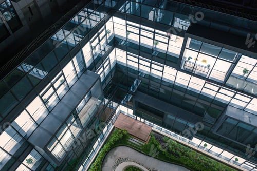 Preview: Courtyard garden of a high-tech company has a curved passage surrounded by transparent glass walls.