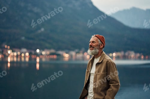 Preview: Happy older man standing in nature park enjoying natural landscape.