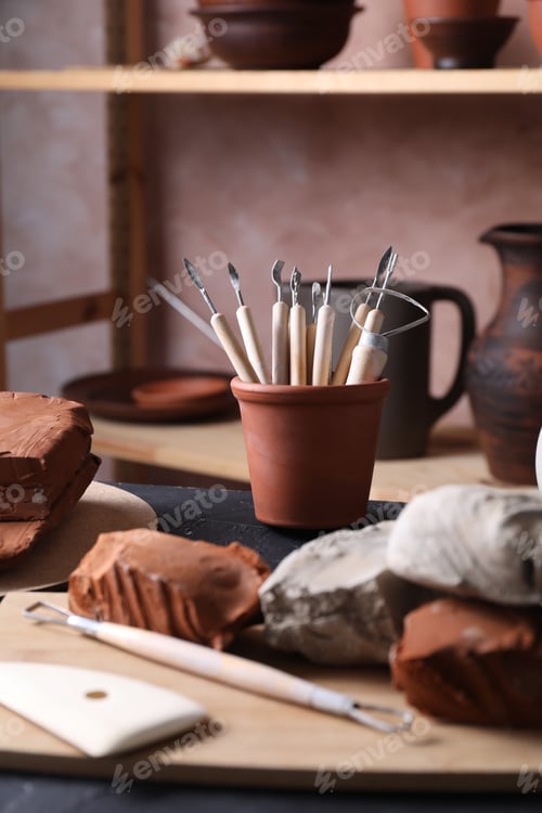 Preview: Clay and set of modeling tools on table in workshop