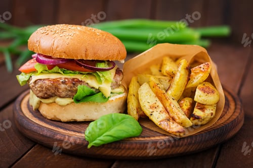 Preview: Big sandwich - hamburger with juicy beef burger, cheese, tomato, and red onion on wooden background