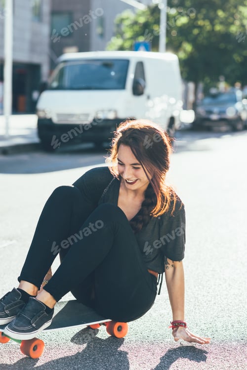 Preview: Young beautiful caucasian woman with septum piercing riding skateboard outdoor