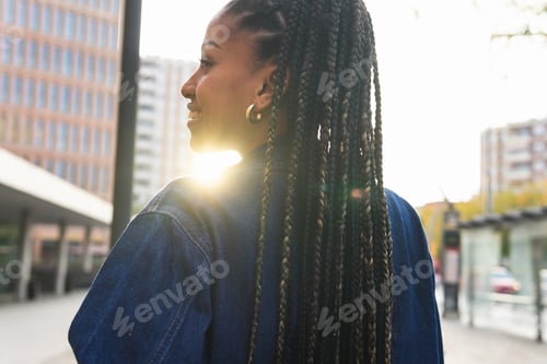Preview: Black woman with Afro braids standing on street